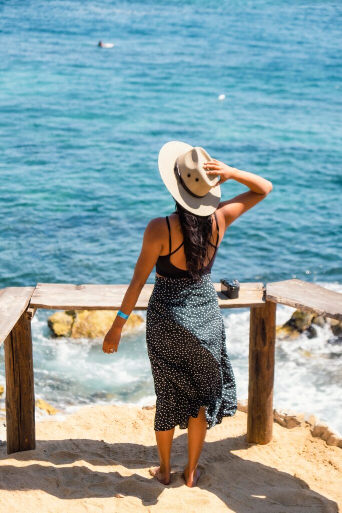 Mujer con estilo de playa, actitud de satisfacción de frente al mar azul